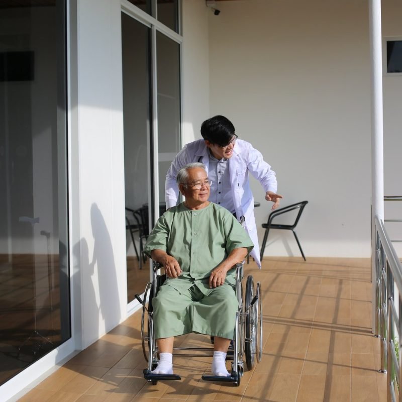 caretaker-helping-senior-man-with-disability-at-checkup-visit.jpg